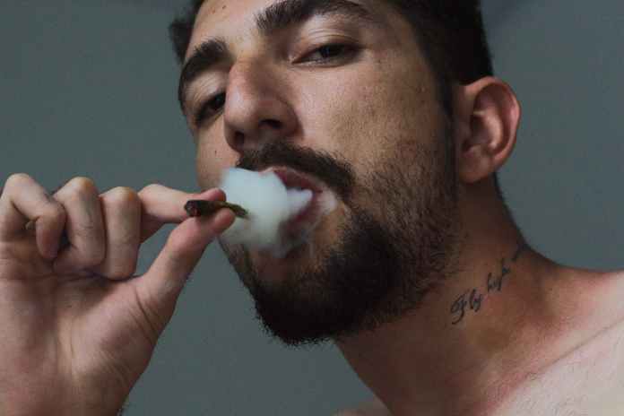 man smoking tobacco inside room