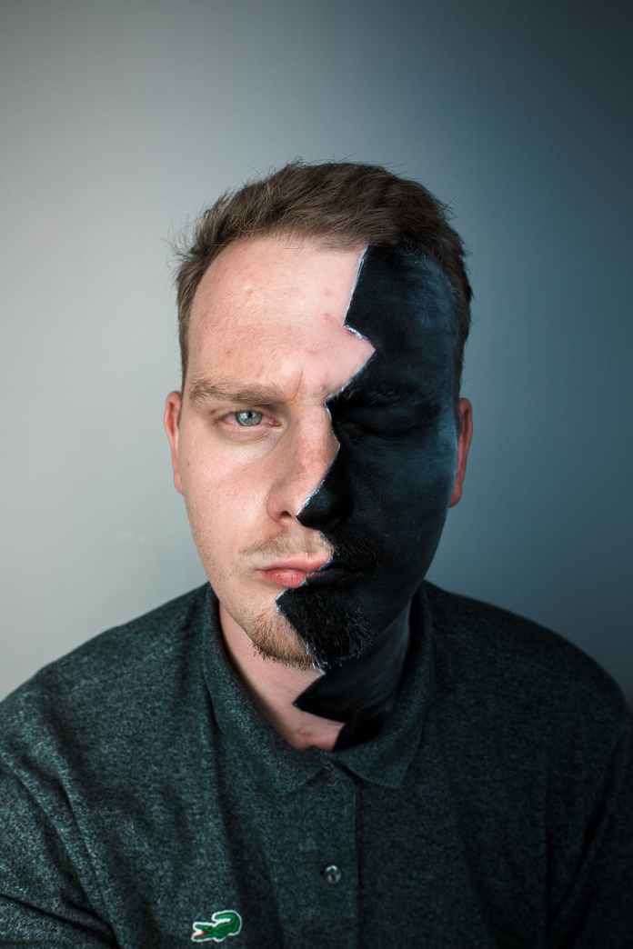 split minded bearded man near wall