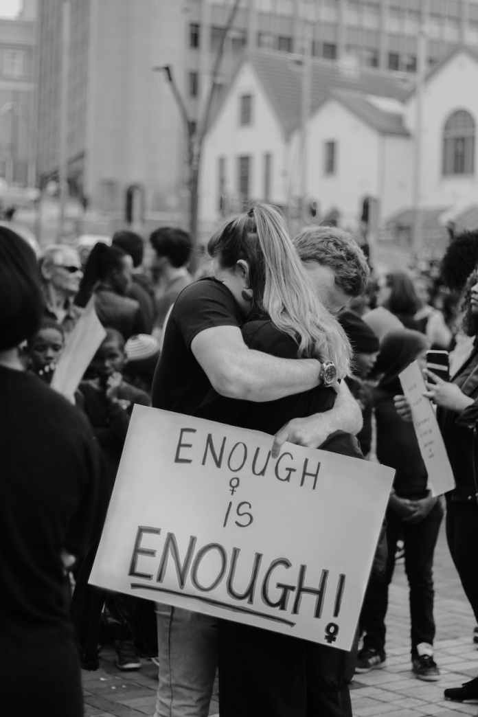 couple hugging and holding sing with enough is enough inscription