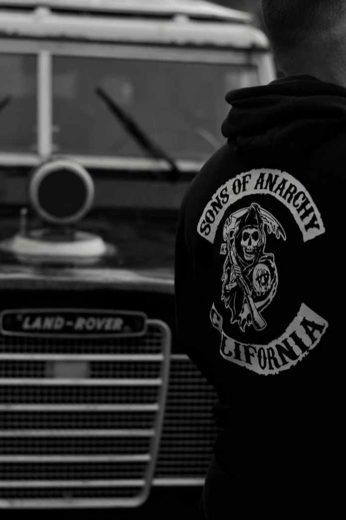 a man in a hoodie standing next to a truck