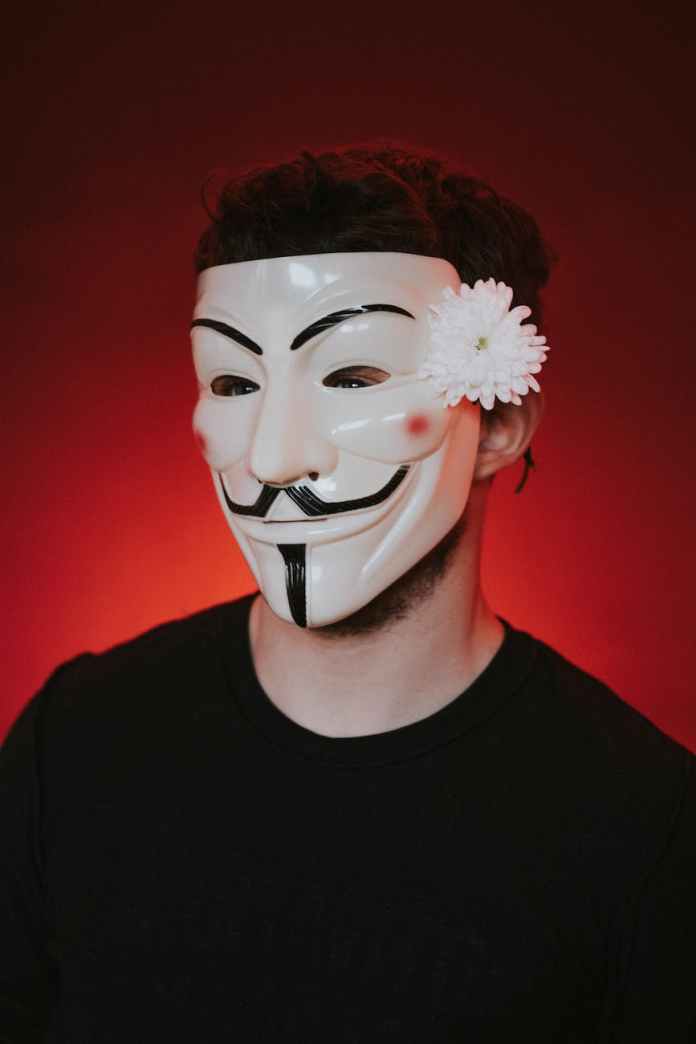 protester in anonymous mask on red background