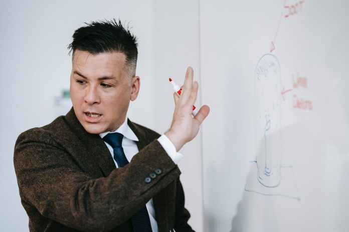 photo of man discussing on white board