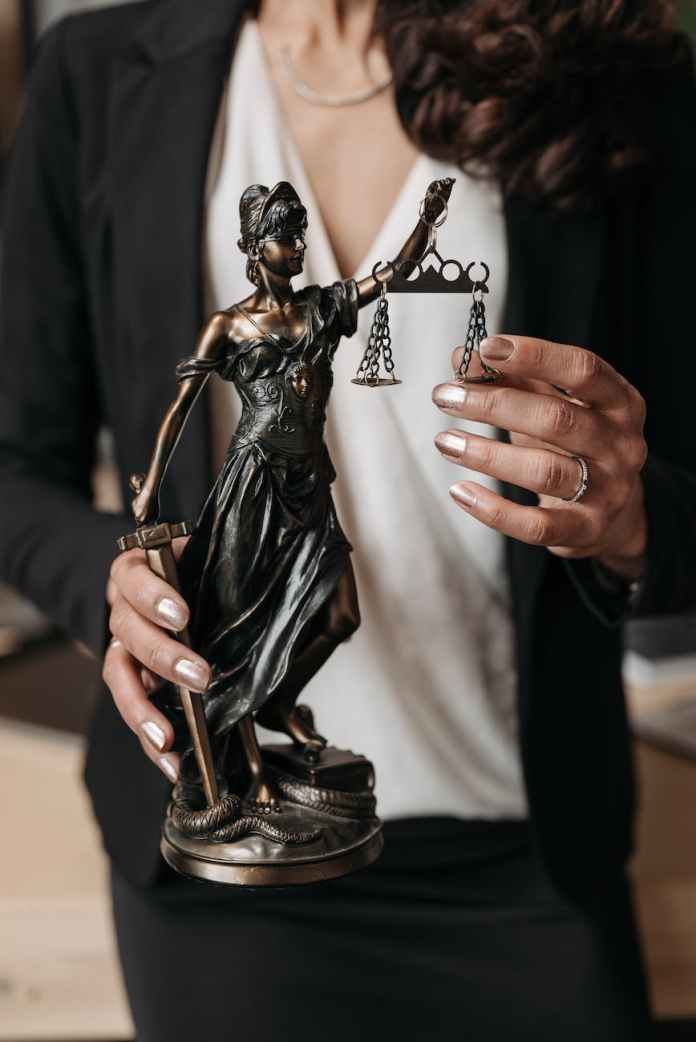 a person holding a statuette of lady justice