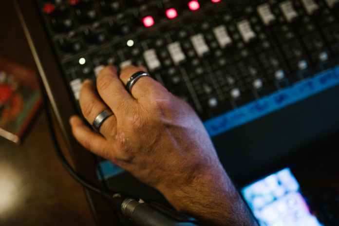 person wearing silver ring using black and gray audio mixer