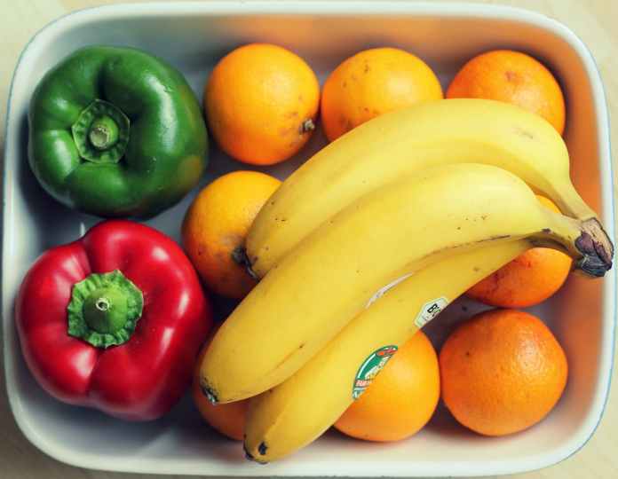 top view photography of yellow bananas and two peppers